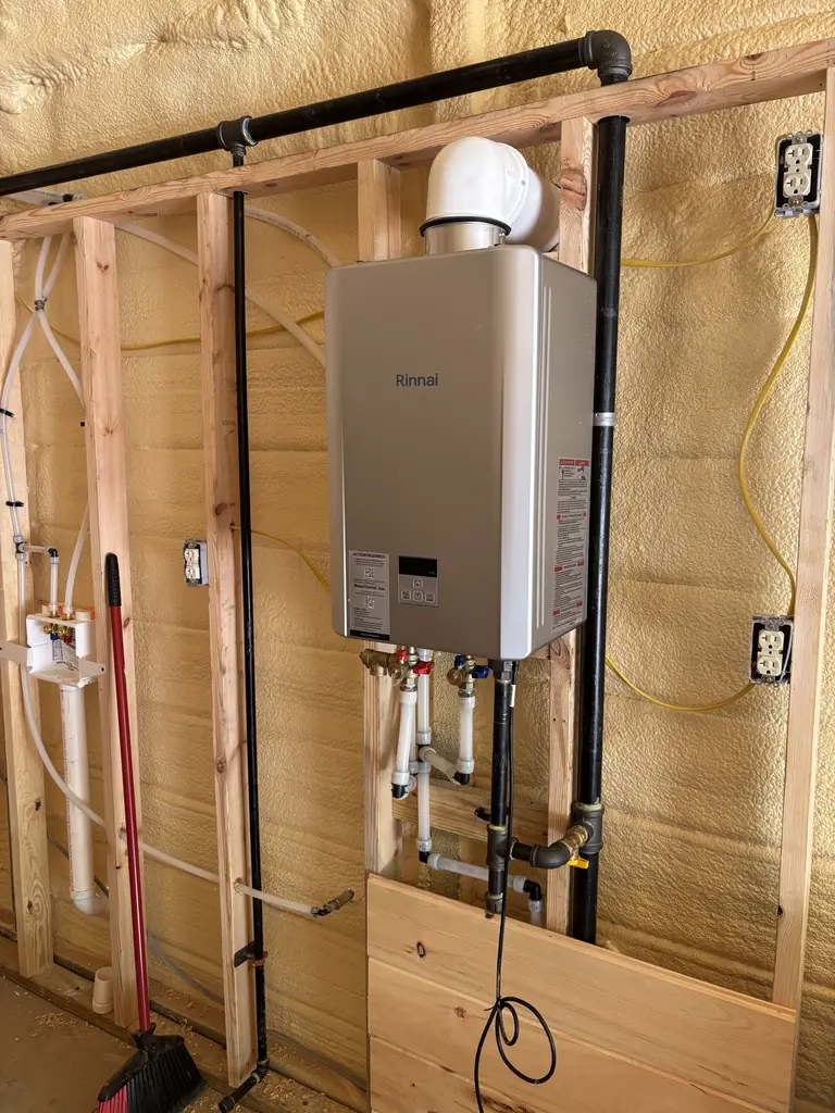 Tankless water heater mounted in the framing of a new build