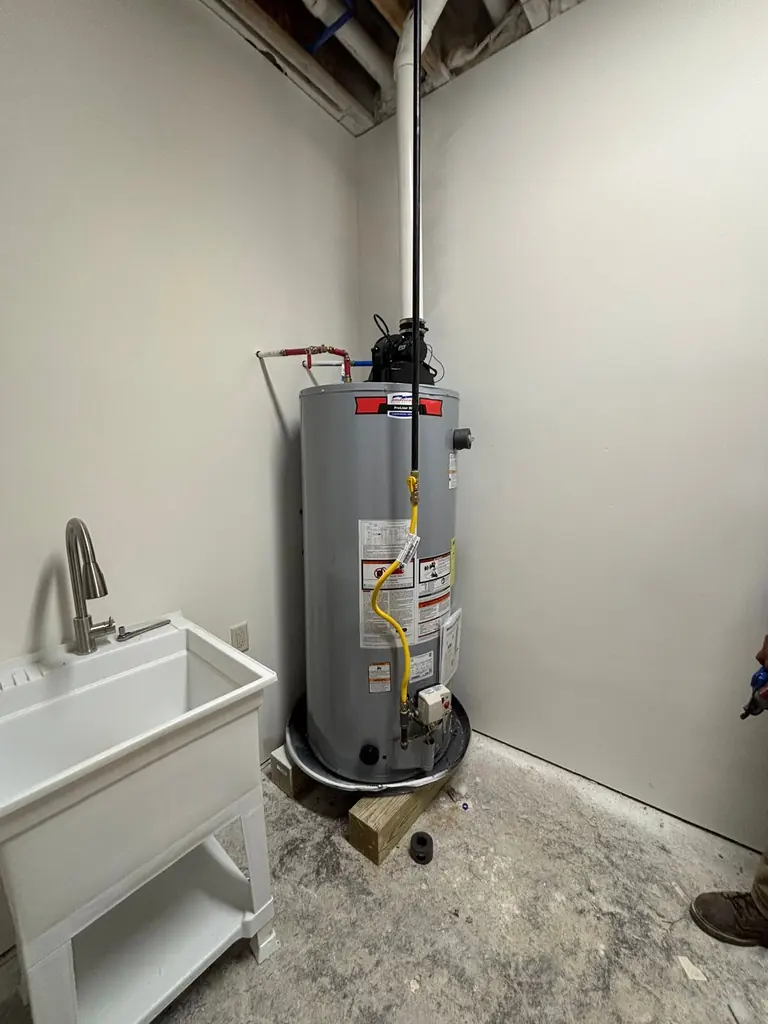 Gas water heater installed beside a utility sink